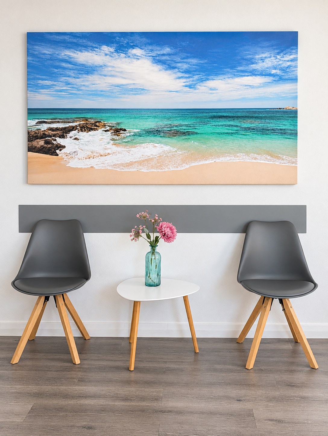 Wartebereich mit zwei Stühlen und einem Strandbild